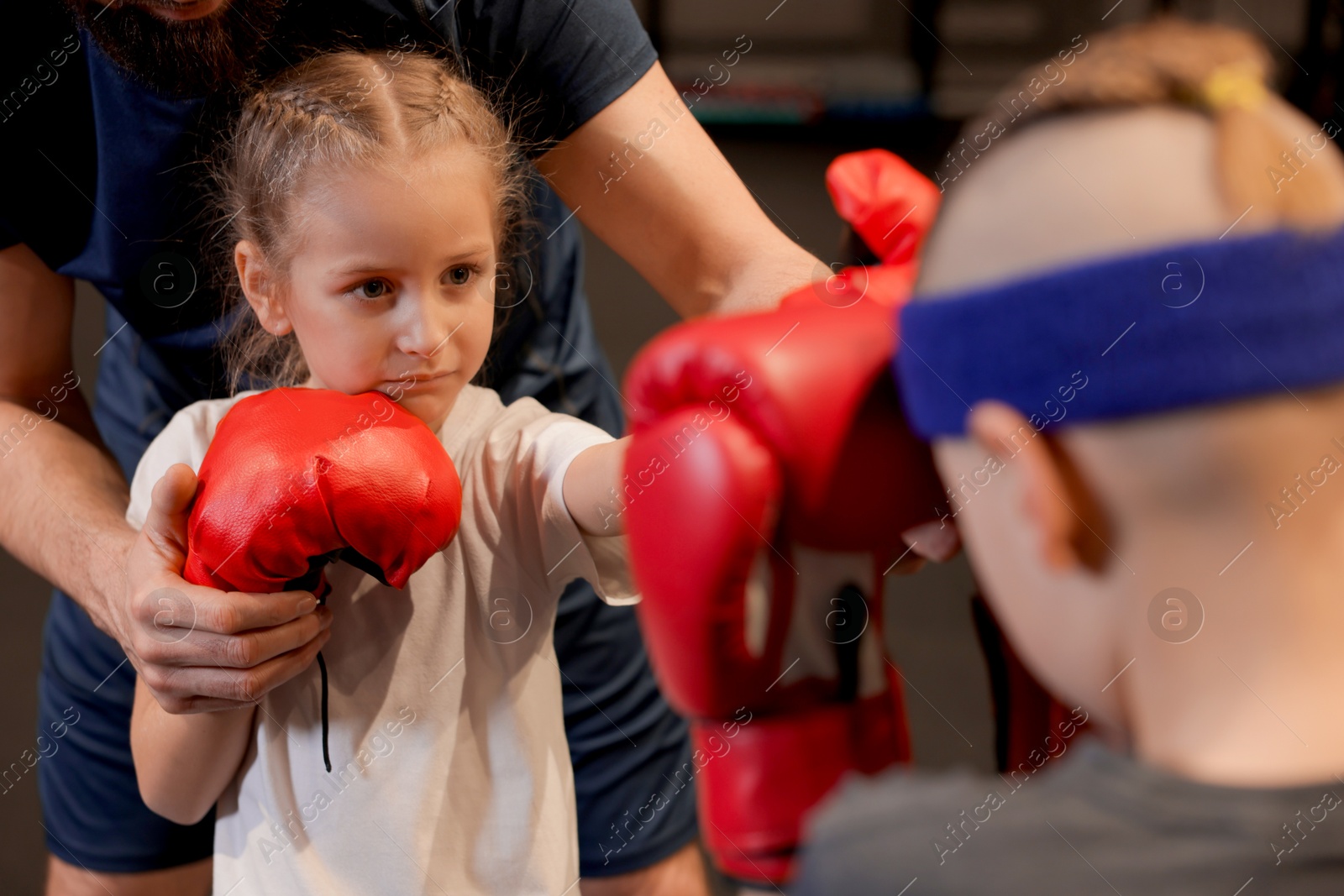 Photo of Children having boxing practice with their coach in training center