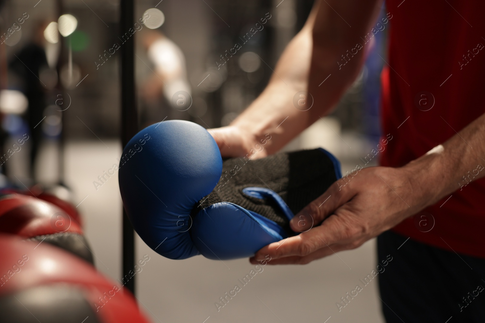 Photo of Man holding protective boxing glove indoors, closeup