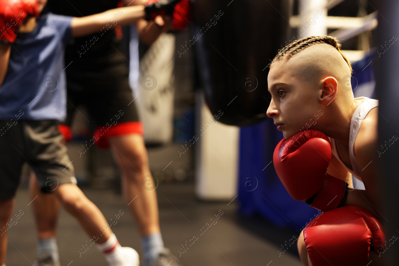 Photo of Children having boxing practice with their coach in training center, selective focus