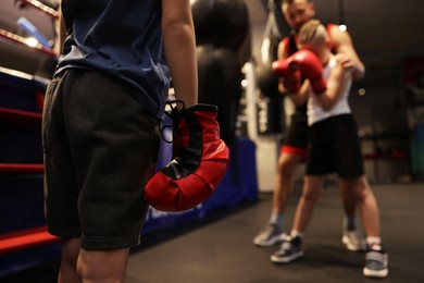 Photo of Girl at boxing practice in training center, closeup