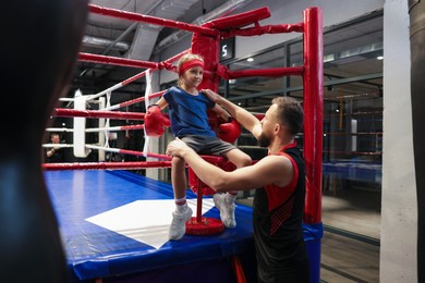 Photo of Coach encouraging girl in boxing ring corner