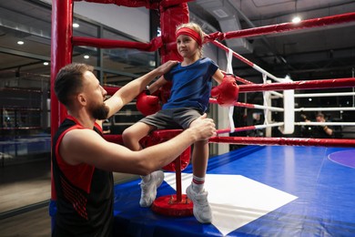 Photo of Coach encouraging girl in boxing ring corner