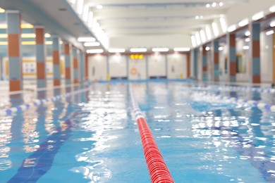 Swimming pool with clean water and lane dividers indoors, closeup