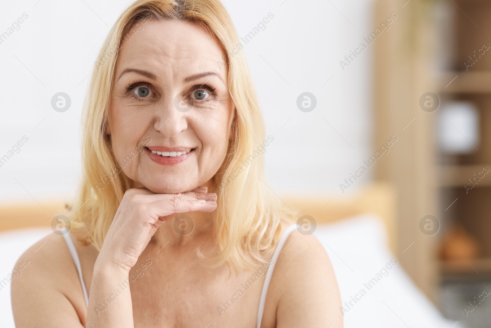 Photo of Portrait of smiling middle aged woman at home. Space for text