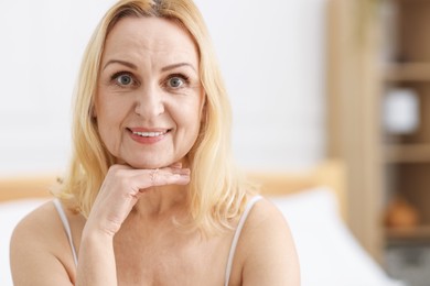 Photo of Portrait of smiling middle aged woman at home. Space for text