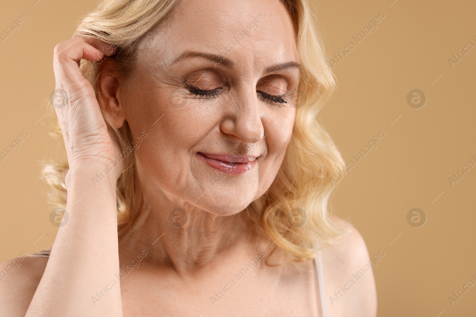 Photo of Beautiful middle aged woman on beige background