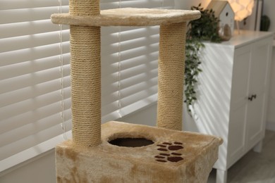 Photo of Stylish cat tree and chest of drawers in living room