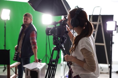 Photo of Man and woman working in modern film studio, selective focus