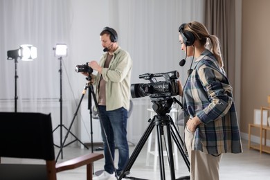 Photo of Man and woman working in modern film studio