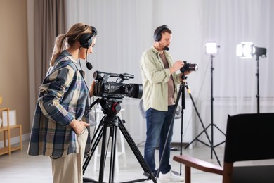 Photo of Man and woman working in modern film studio