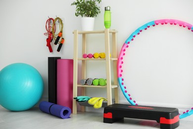 Photo of Different fitness equipment near white wall indoors