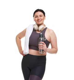 Plus size woman in gym clothes with water bottle, headphones and towel on white background