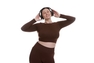 Plus size woman in gym clothes and headphones on white background