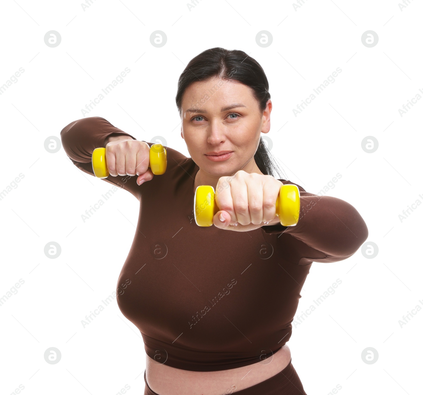 Photo of Plus size woman in gym clothes doing exercise with dumbbells on white background