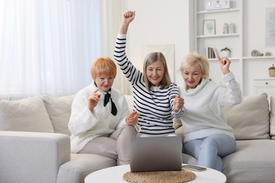 Friendship. Senior women watching something on laptop at home