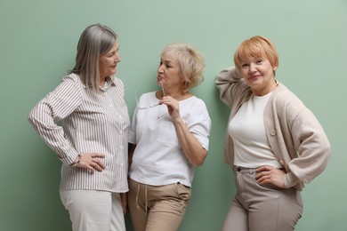 Photo of Friendship. Portrait of senior women on pale green background