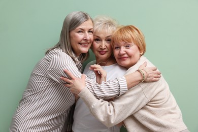 Photo of Friendship. Portrait of senior women on pale green background