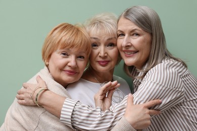 Photo of Friendship. Portrait of senior women on pale green background