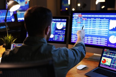 Photo of Financial trading specialist working in office at night, back view