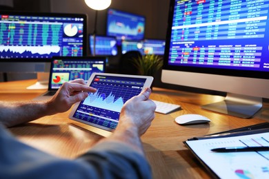 Photo of Financial trading specialist with tablet in office at night, closeup