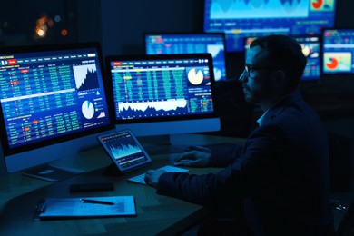 Photo of Financial trading specialist working in office at night