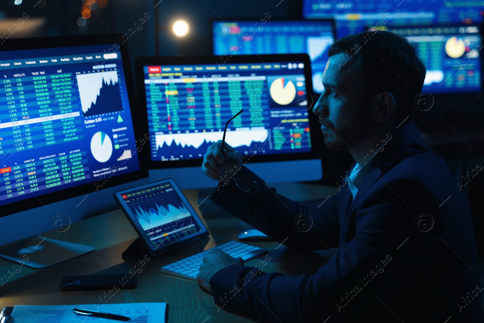 Photo of Financial trading specialist working in office at night