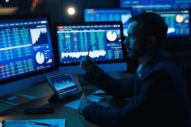 Photo of Financial trading specialist working in office at night