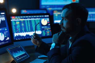 Photo of Financial trading specialist working in office at night