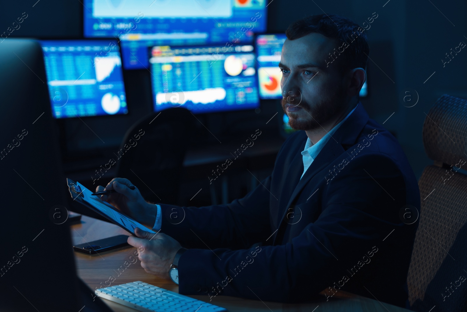 Photo of Financial trading specialist working in office at night