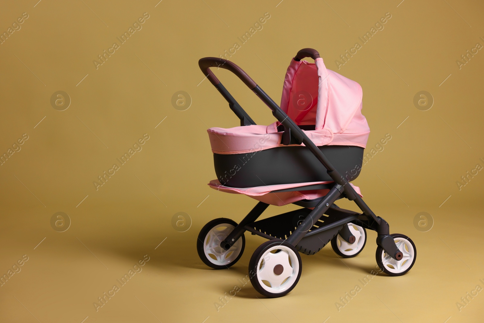 Photo of Stylish doll stroller on olive background, space for text. Kid's toy