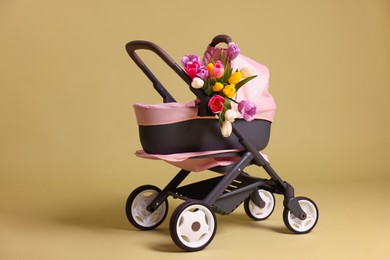 Stylish doll stroller and tulips on olive background. Kid's toy