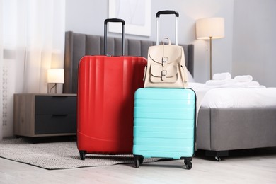 Stylish suitcases with backpack in hotel room