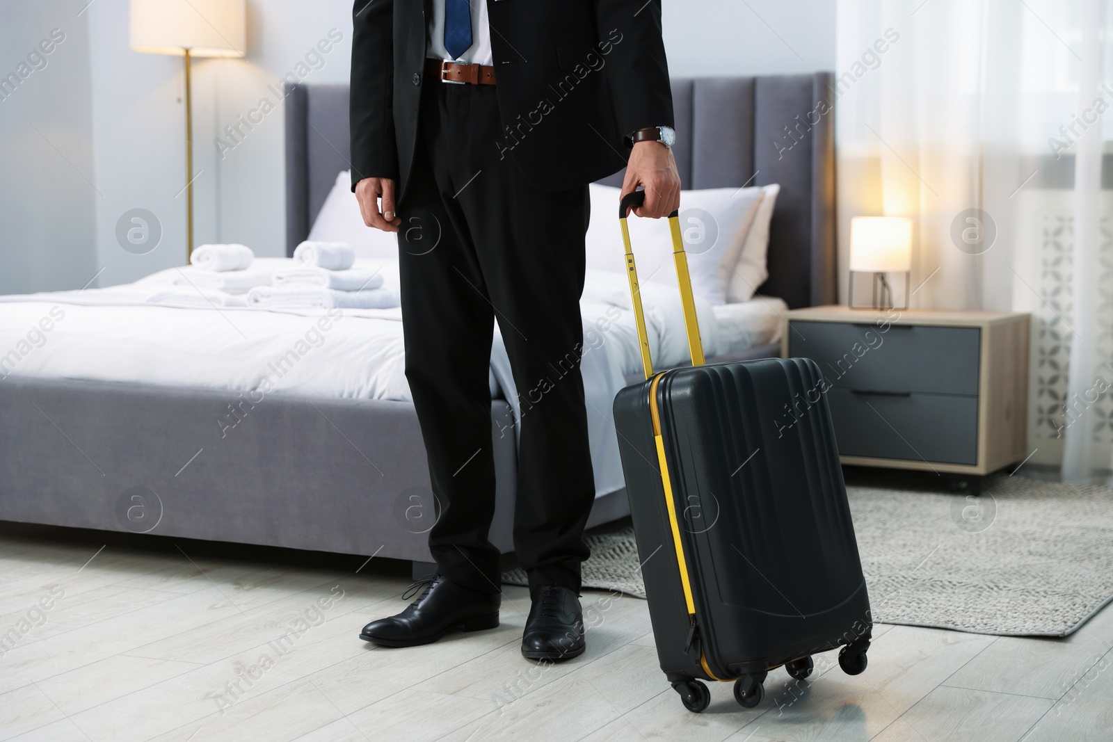 Photo of Businessman with suitcase in hotel room, closeup