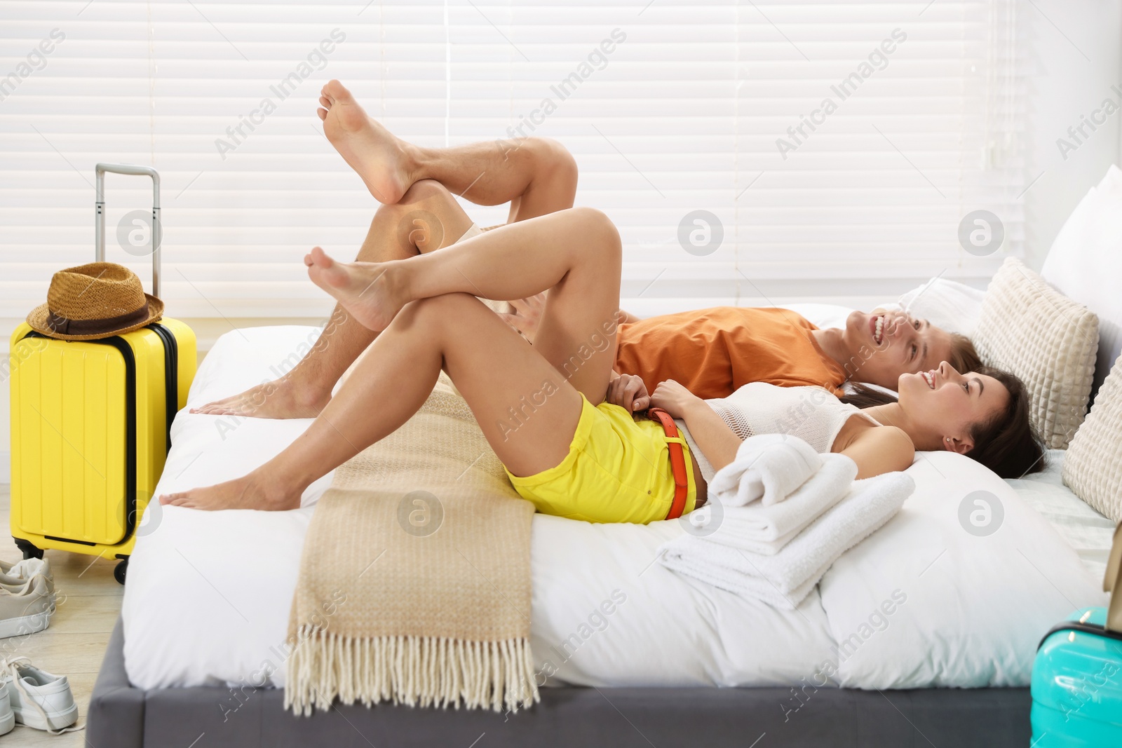 Photo of Happy couple lying on bed in their hotel room