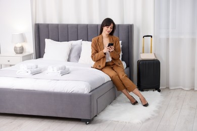 Photo of Businesswoman with smartphone in her hotel room