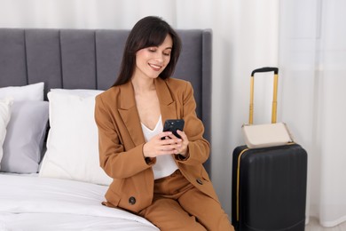 Photo of Businesswoman with smartphone in her hotel room