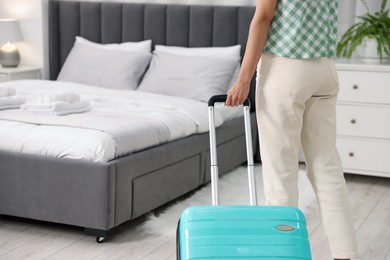 Woman with suitcase in hotel room, closeup