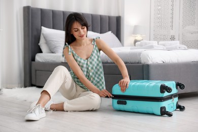 Woman unpacking her suitcase in hotel room