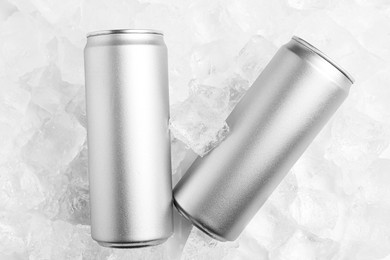 Photo of Refreshing drinks in cans on ice cubes, top view