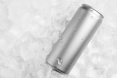 Photo of Refreshing drink in can on ice cubes, top view. Space for text