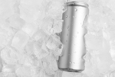 Photo of Refreshing drink in can on ice cubes, top view. Space for text
