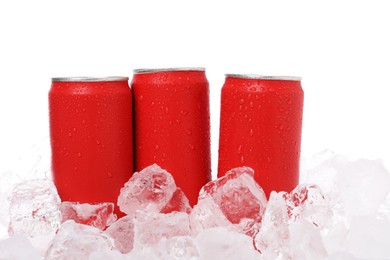 Photo of Refreshing drinks in cans on ice cubes against white background