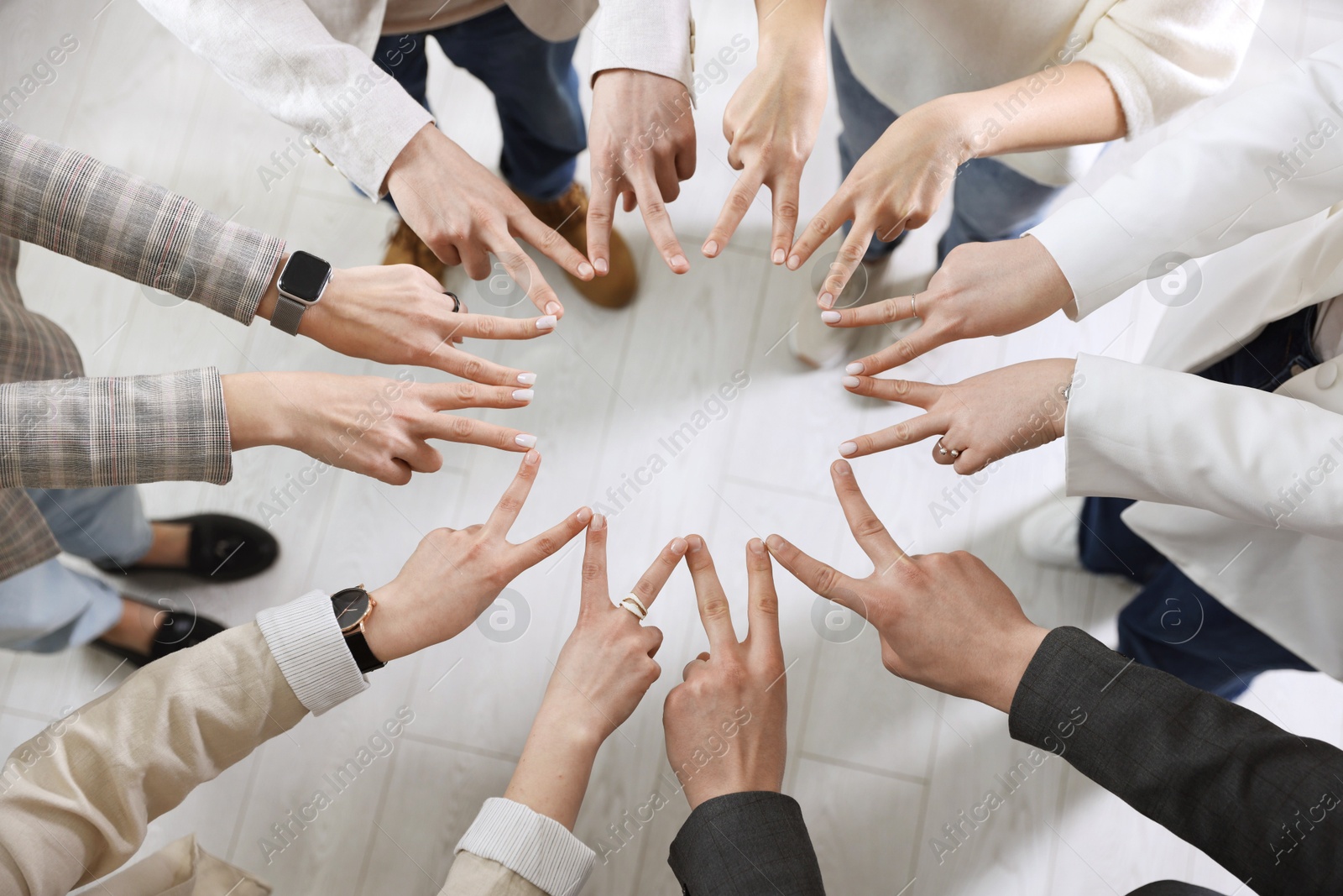 Photo of Unity concept. People showing V-sign with both hands and joining their fingers together in circle