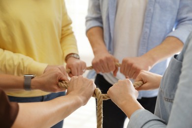 Photo of Unity concept. People holding rope together indoors, closeup