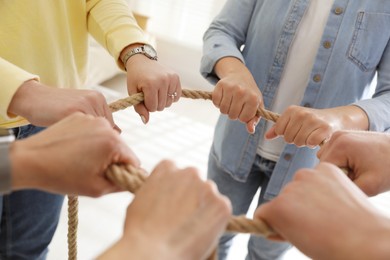 Unity concept. People holding rope together indoors, closeup