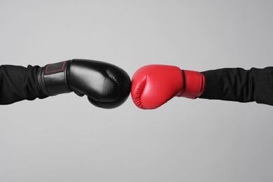 Photo of Business competition. Women in boxing gloves on grey background, closeup