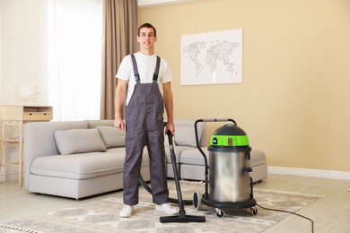 Photo of Cleaning service worker with professional hoover indoors