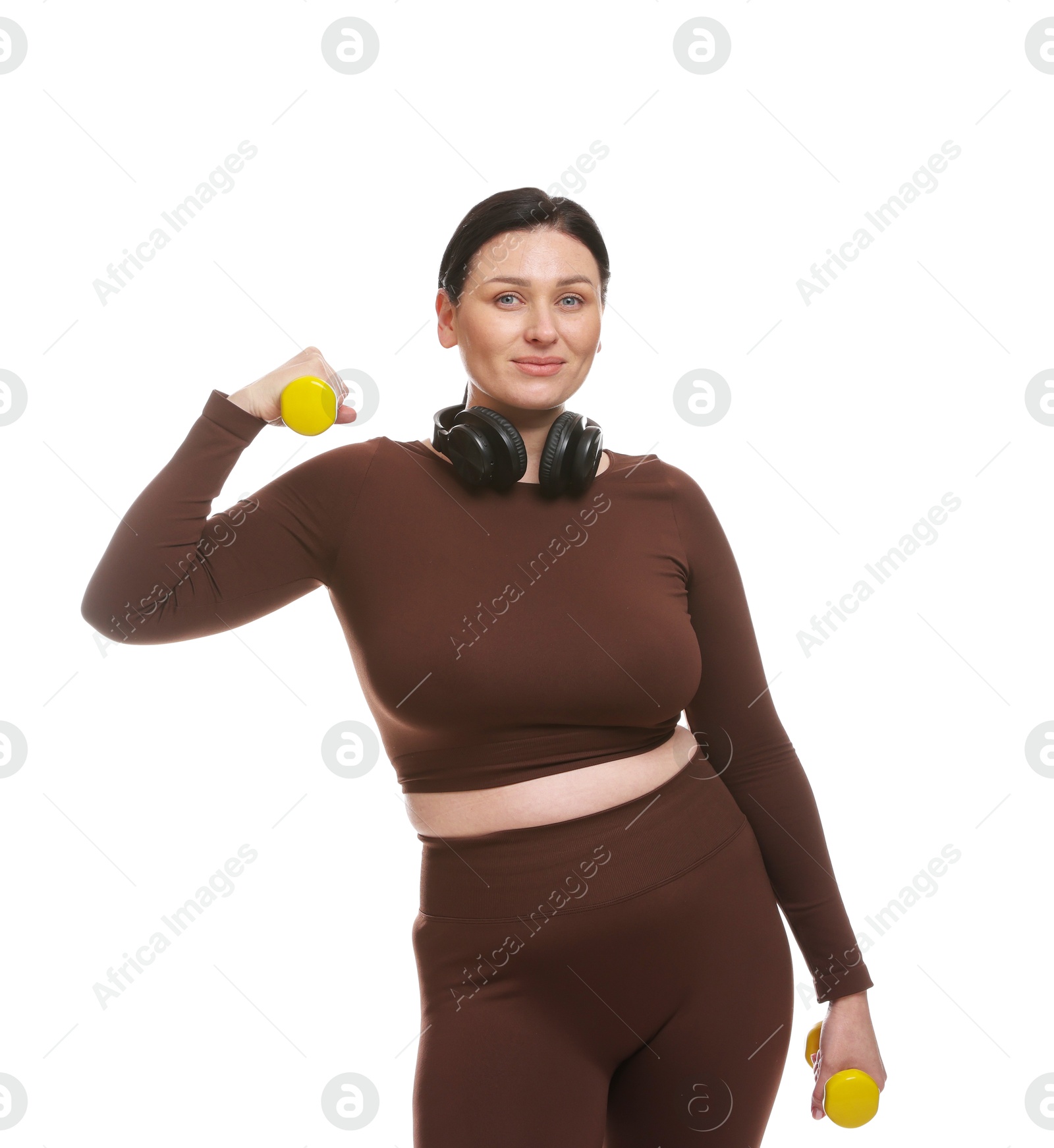 Photo of Plus size woman in gym clothes doing exercise with dumbbells on white background