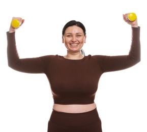 Plus size woman in gym clothes doing exercise with dumbbells on white background