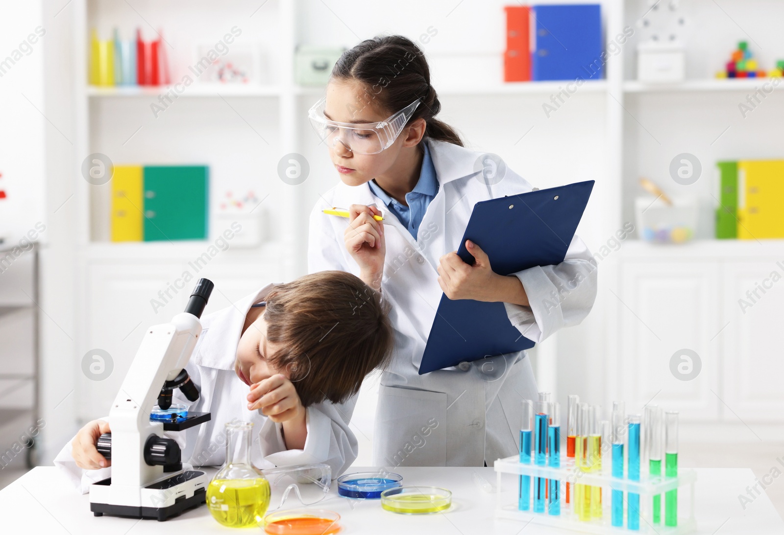 Photo of Children doing chemical experiment at desk indoors